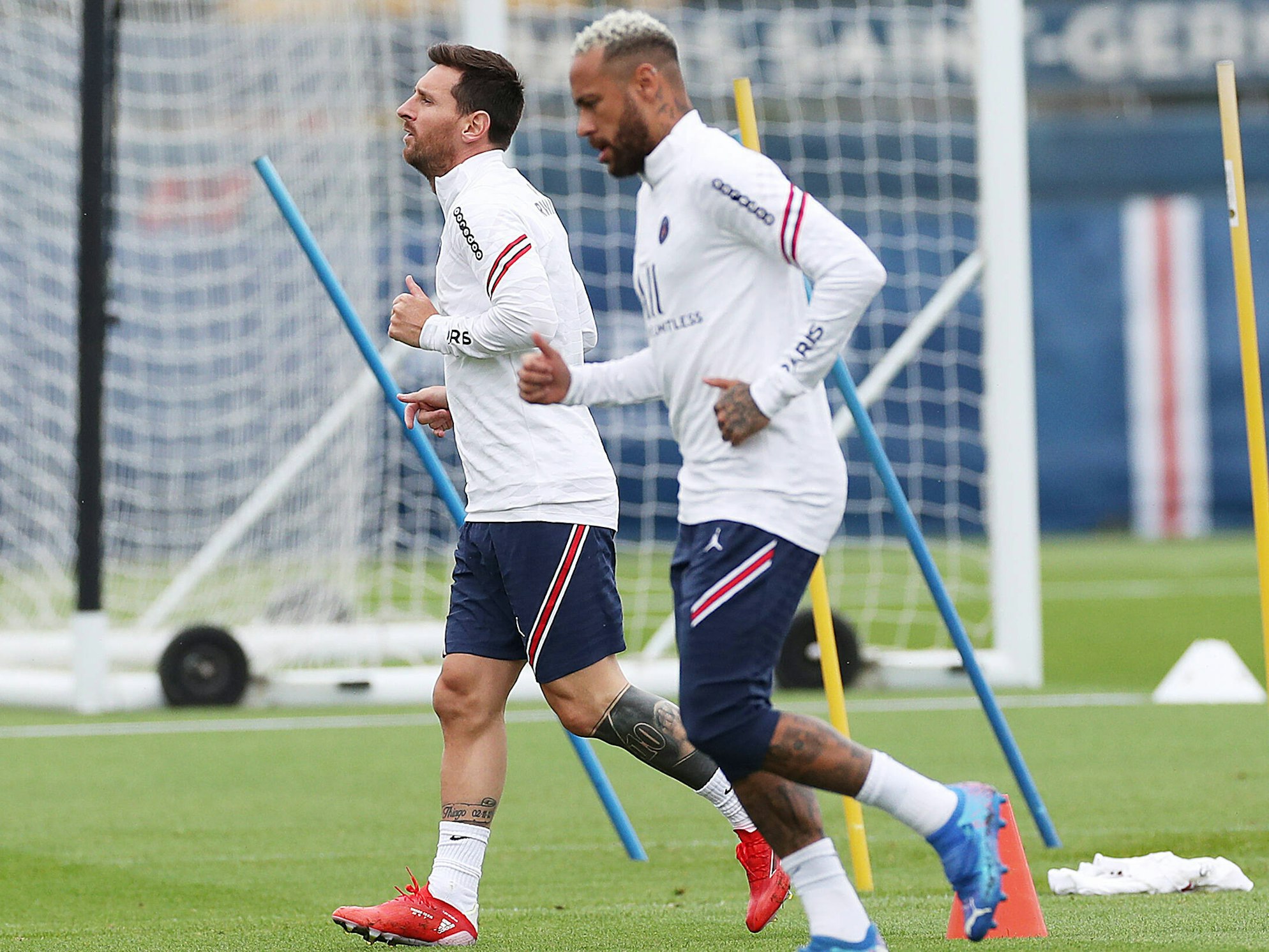 Messi und Neymar laufen nebeneinander über den Trainingsplatz.