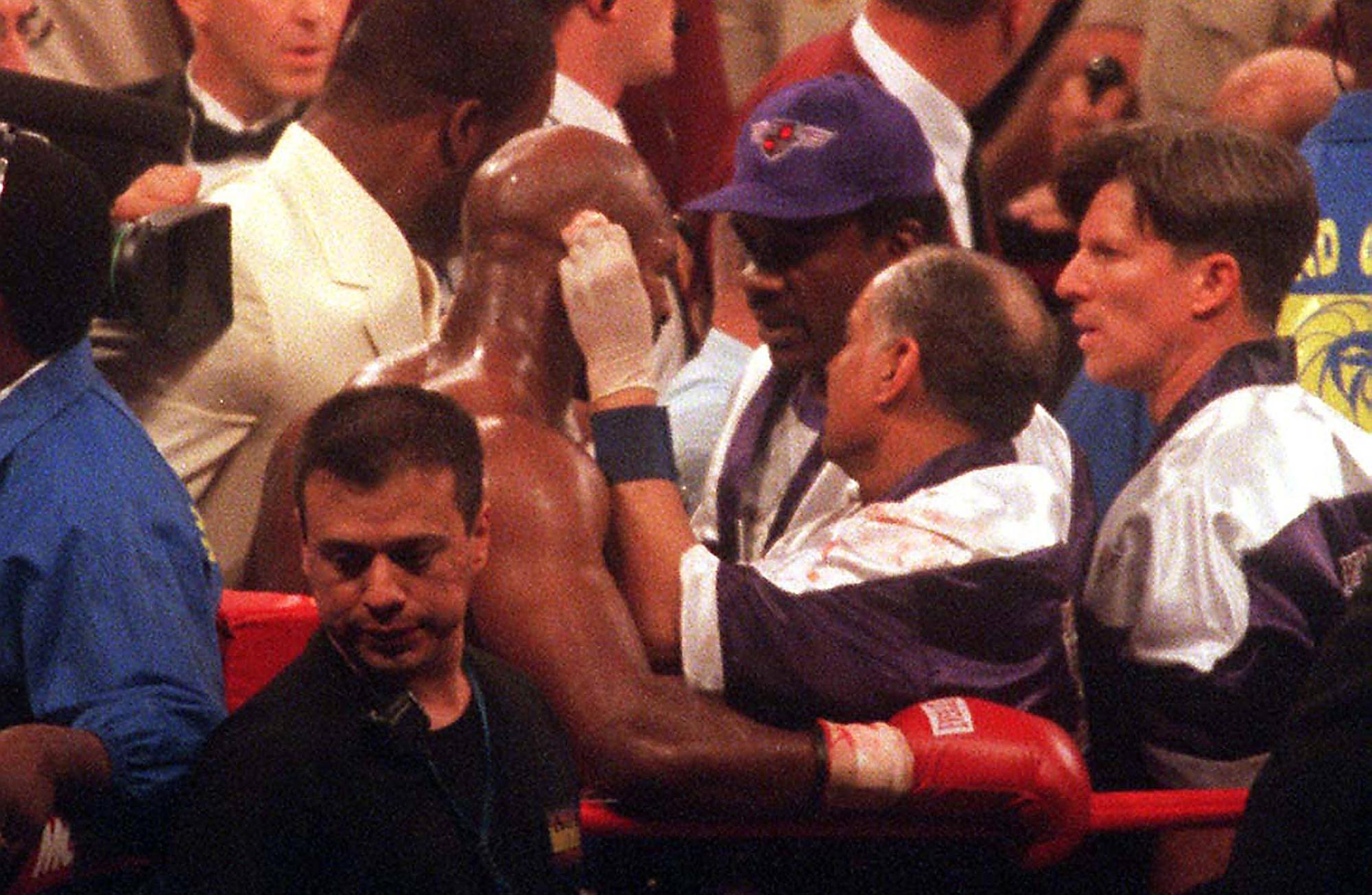 Nach dem Biss von Tyson wird Holyfield von seinen Betreuern medizinisch versorgt.