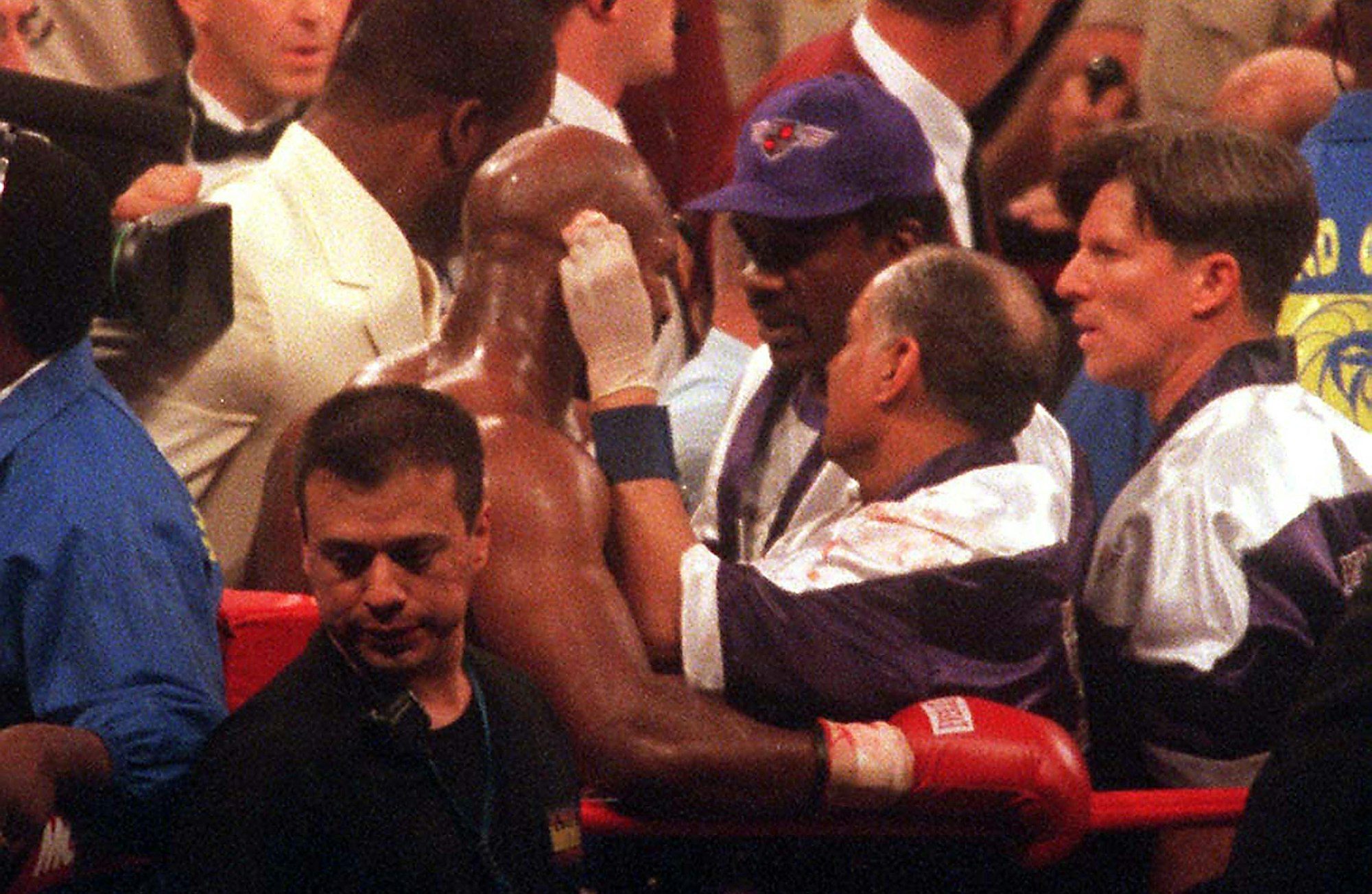 Nach dem Biss von Tyson wird Holyfield von seinen Betreuern medizinisch versorgt.