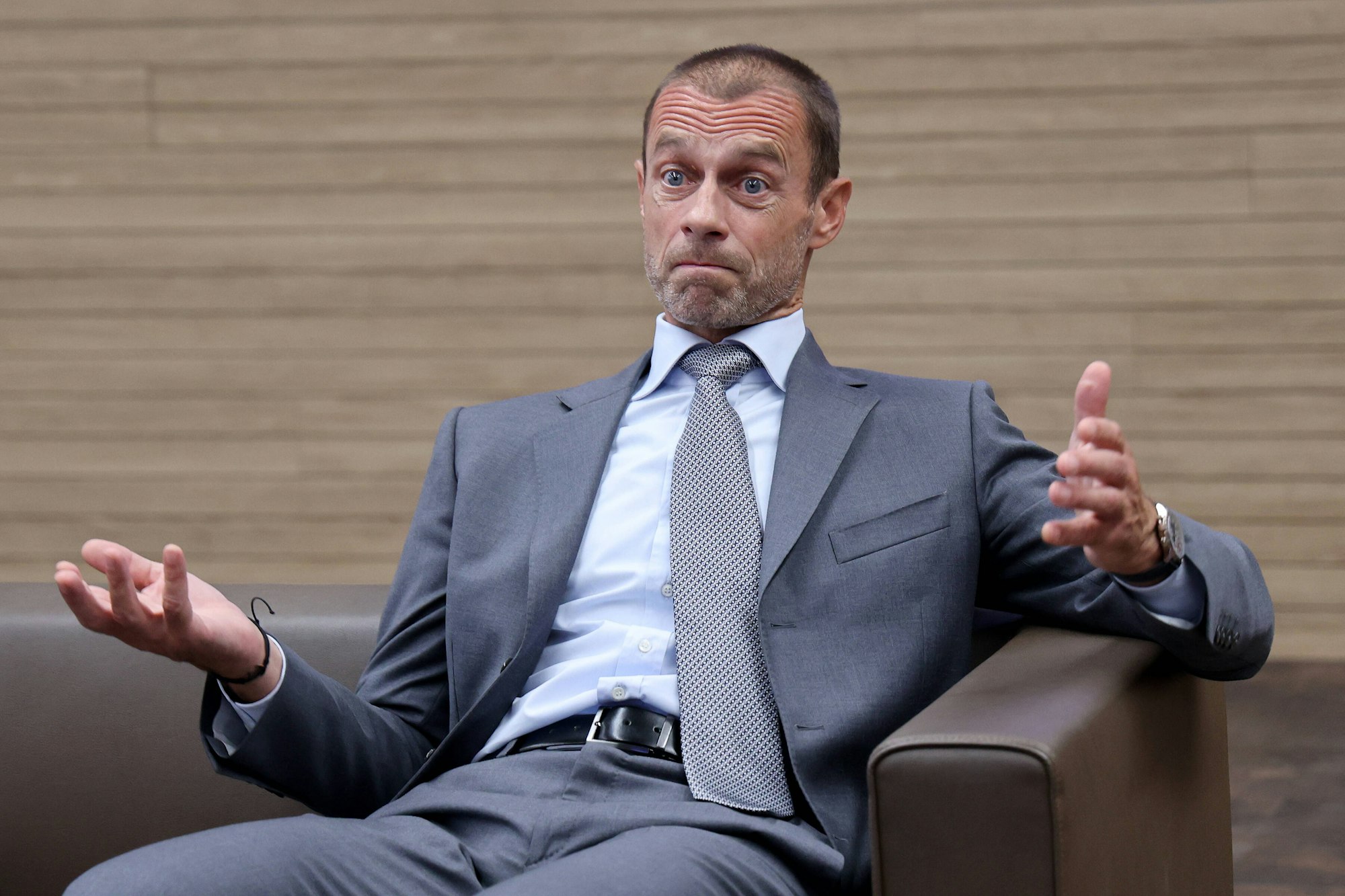 UEFA-Präsident Aleksander Ceferin sitzt auf einem Sessel und reißt die Augen auf.