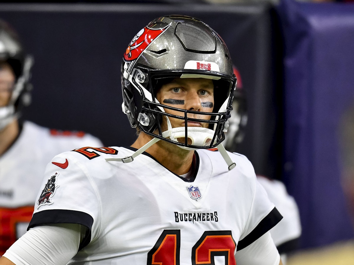 Tom Brady, mit Helm, Trikot und schwarz untermalten Augen, guckt in die Kamera.