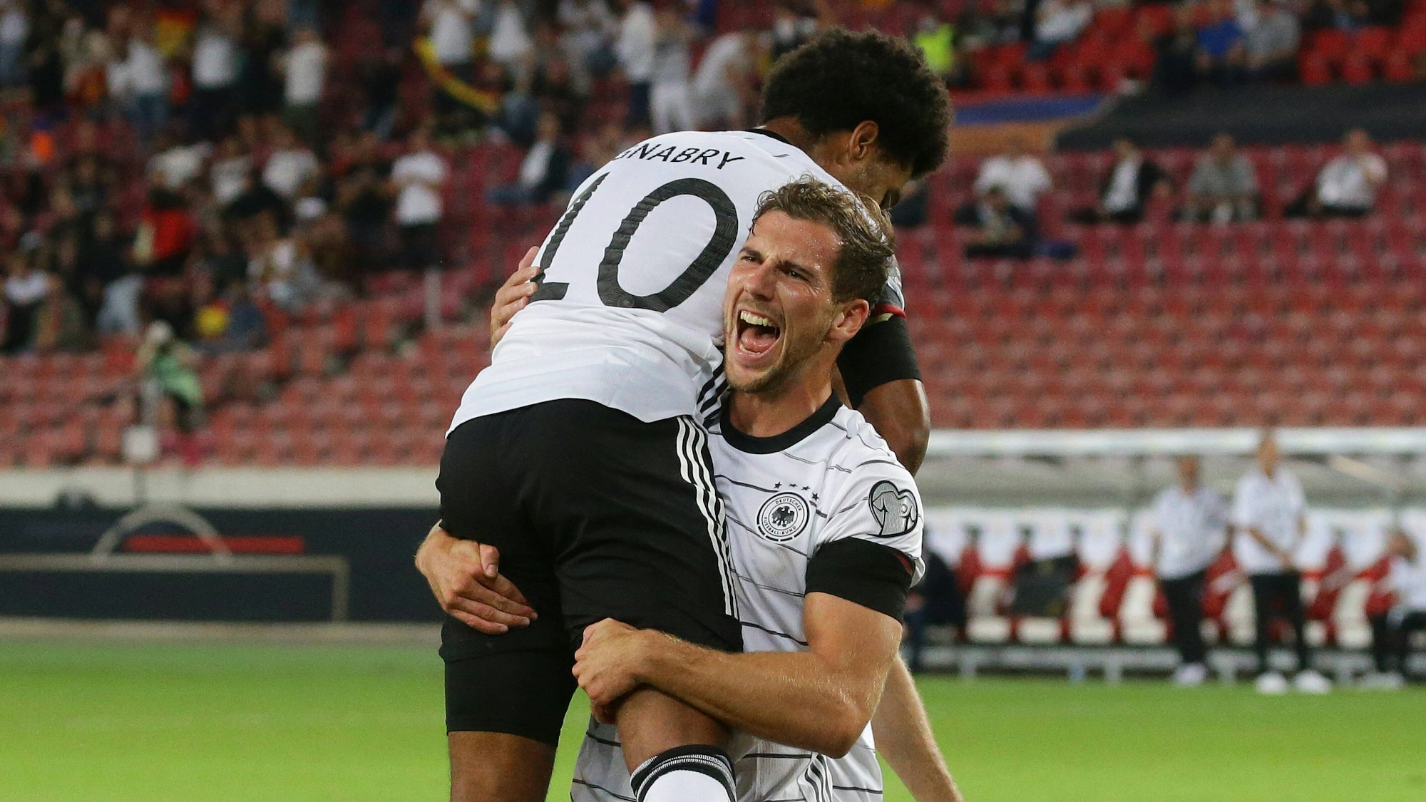 Leon Goretzka hebt Serge Gnabry nach dessen Tor in die Höhe.