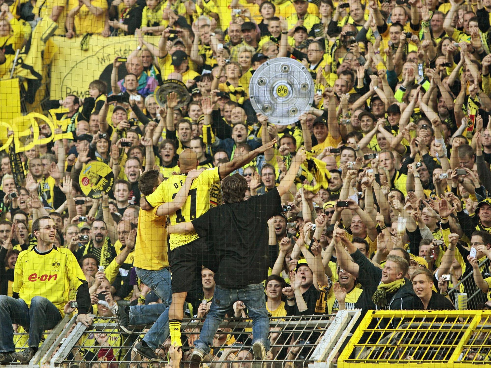 Dede steht auf dem Zaun der Südtribüne und feiert mit den Fans die Meisterschaft 2011.