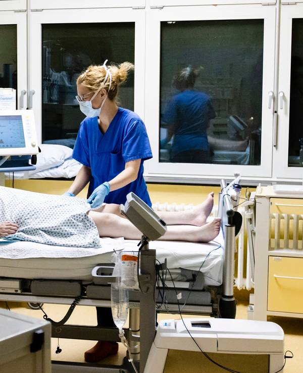 Krankenschwester am Bett eines Intensivpatienten.