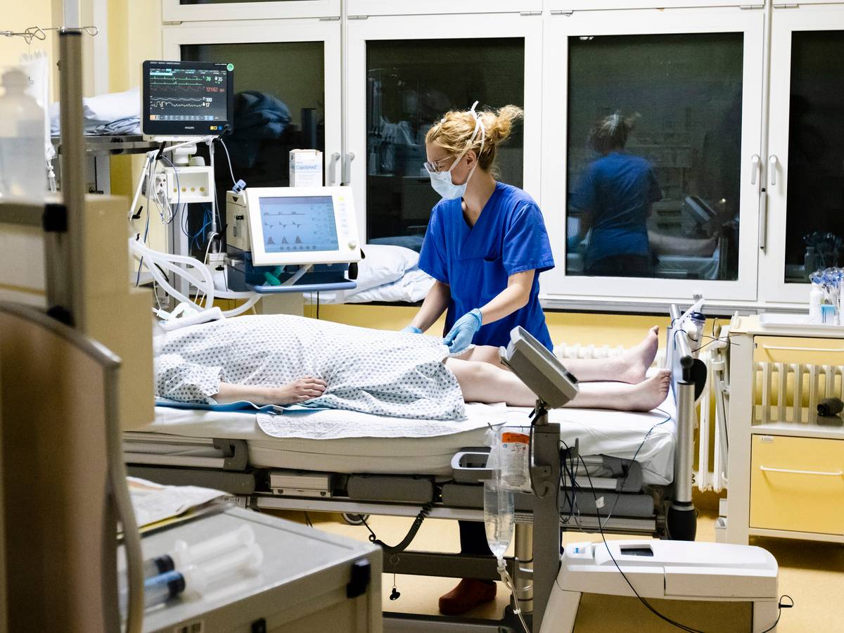 Krankenschwester am Bett eines Intensivpatienten.