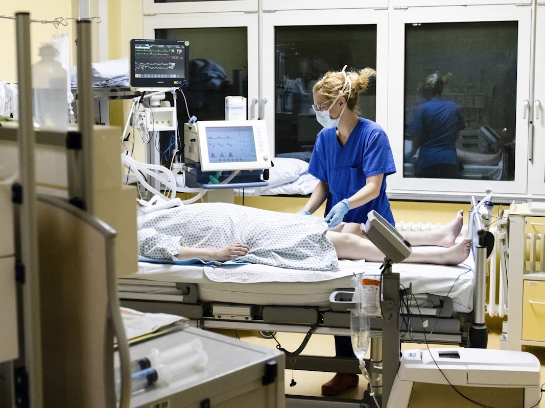 Krankenschwester am Bett eines Intensivpatienten.