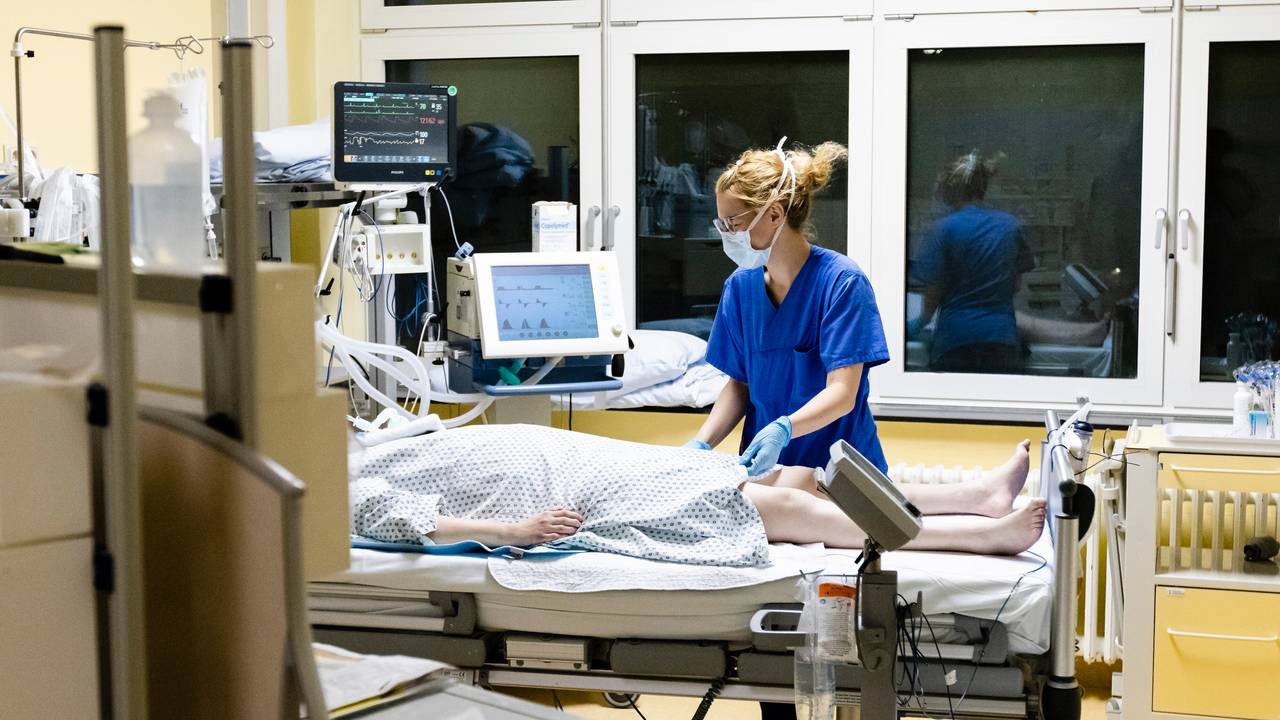 Krankenschwester am Bett eines Intensivpatienten.