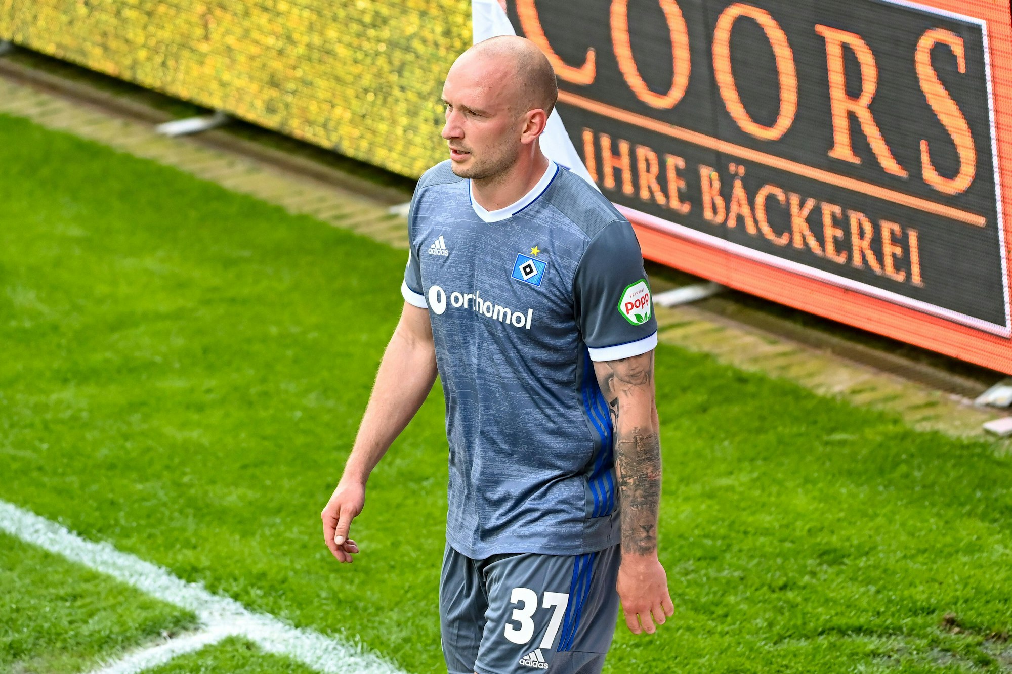 Toni Leister steht auf dem Platz, er trägt das graue Auswärtstrikot des HSV.