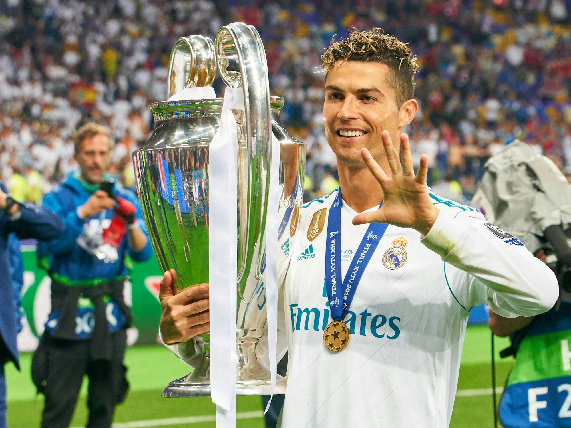 Ronaldo hält den Henkelpott in der rechten Hand und spreizt die andere Hand.