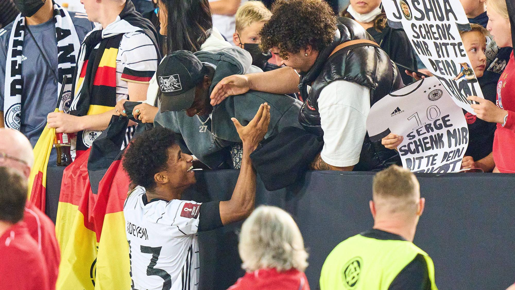 Karim Adeyemi wird von seinen Bekannten auf der Tribüne abgeklatscht.