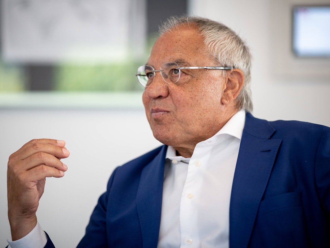 Felix Magath sitzt und gestikuliert mit der rechten Hand.