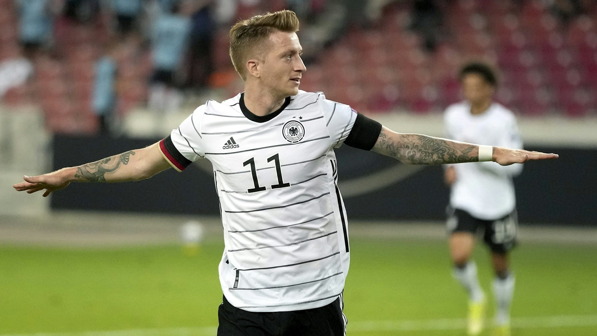 Marco Reus breitet die Arme aus und feiert sein Tor gegen Armenien.