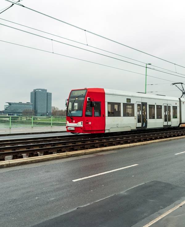Eine Straßenbahn fährt über eine Brücke in Köln.