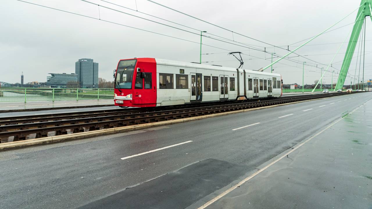 Eine Straßenbahn fährt über eine Brücke in Köln.