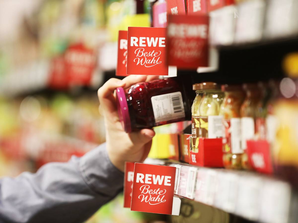 Ein Mann nimmt in unserem Symbolbild ein Glas aus dem Regal einer Rewe-Filiale. Vielerorts sind wieder Weihnachtsprodukte erhältlich, die Kundschaft zeigt sich auf Twitter gespalten.