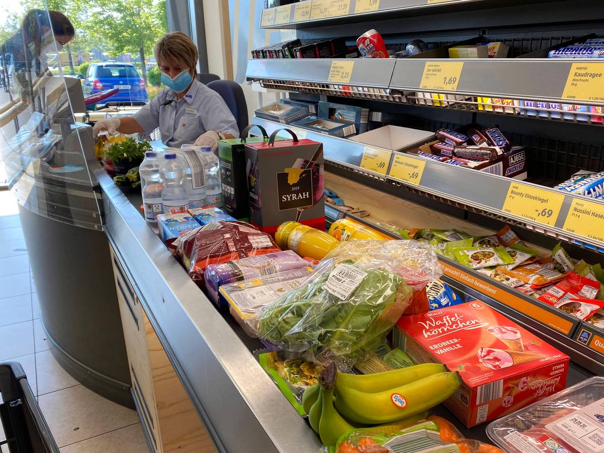 Lebensmittel liegen auf einem Kassenband an einer Supermarktkasse.