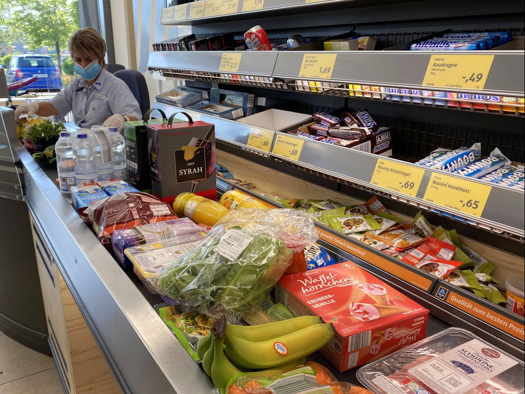 Lebensmittel liegen auf einem Kassenband an einer Supermarktkasse.