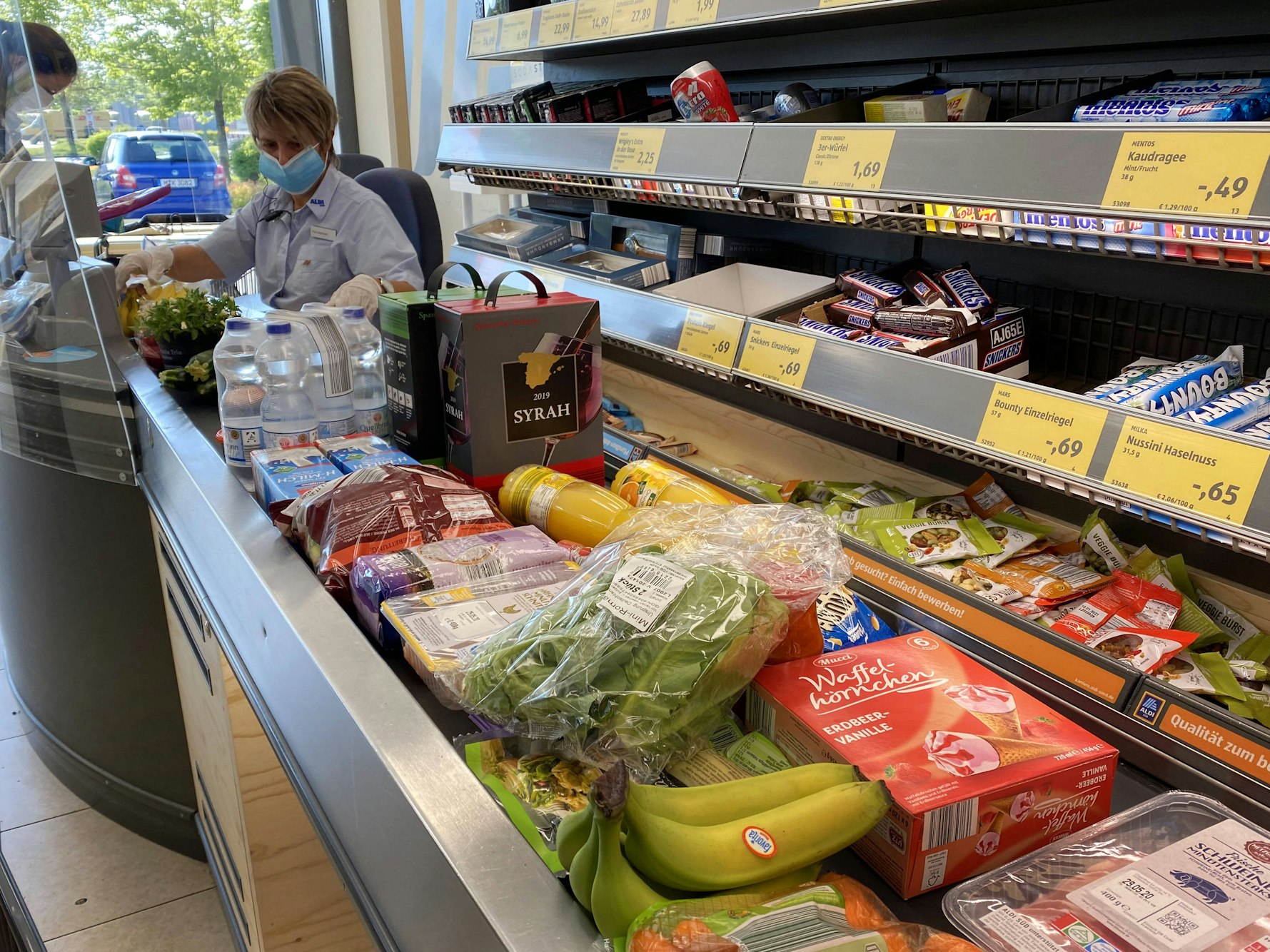 Lebensmittel liegen auf einem Kassenband an einer Supermarktkasse.