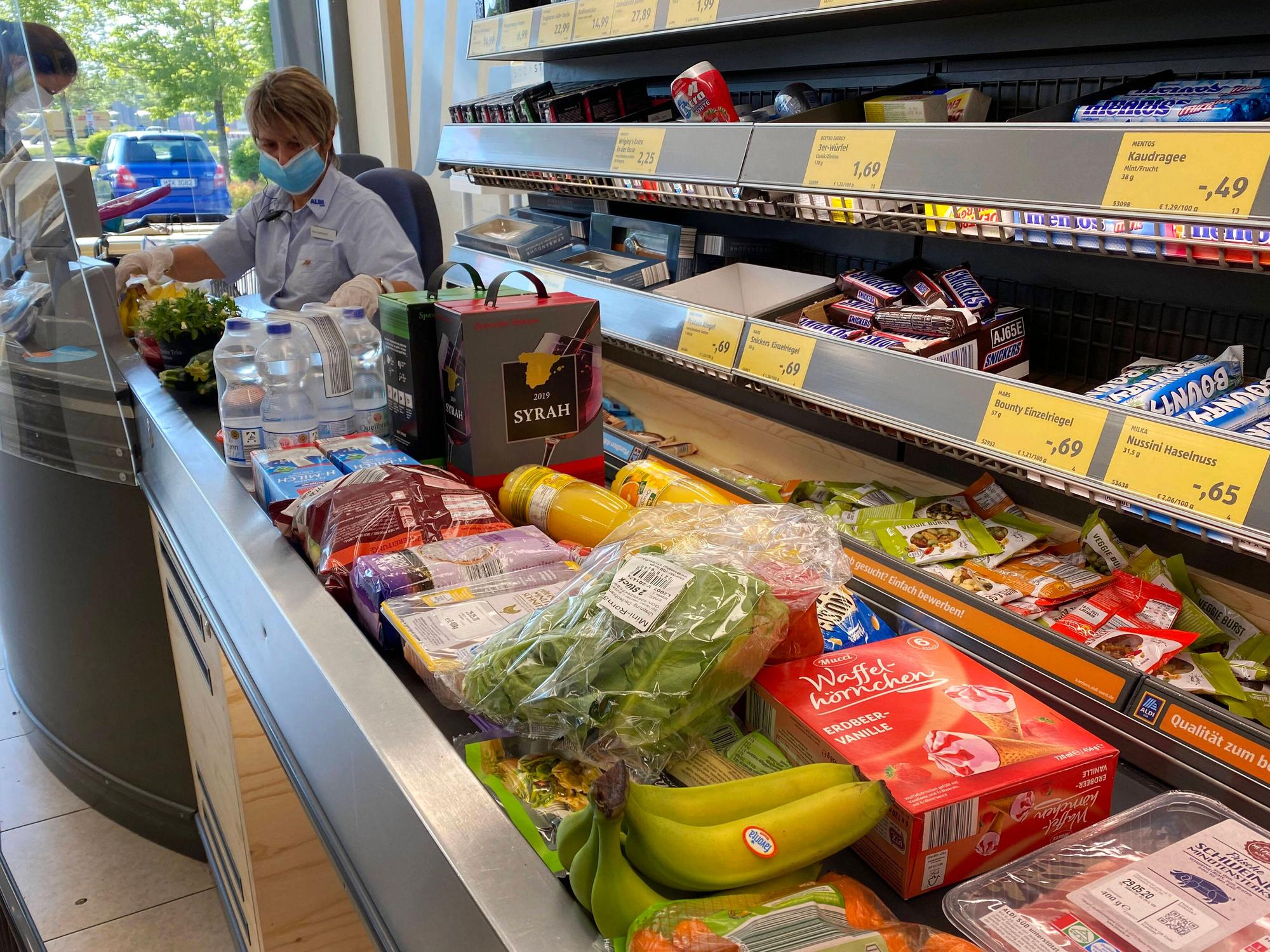 Lebensmittel liegen auf einem Kassenband an einer Supermarktkasse.