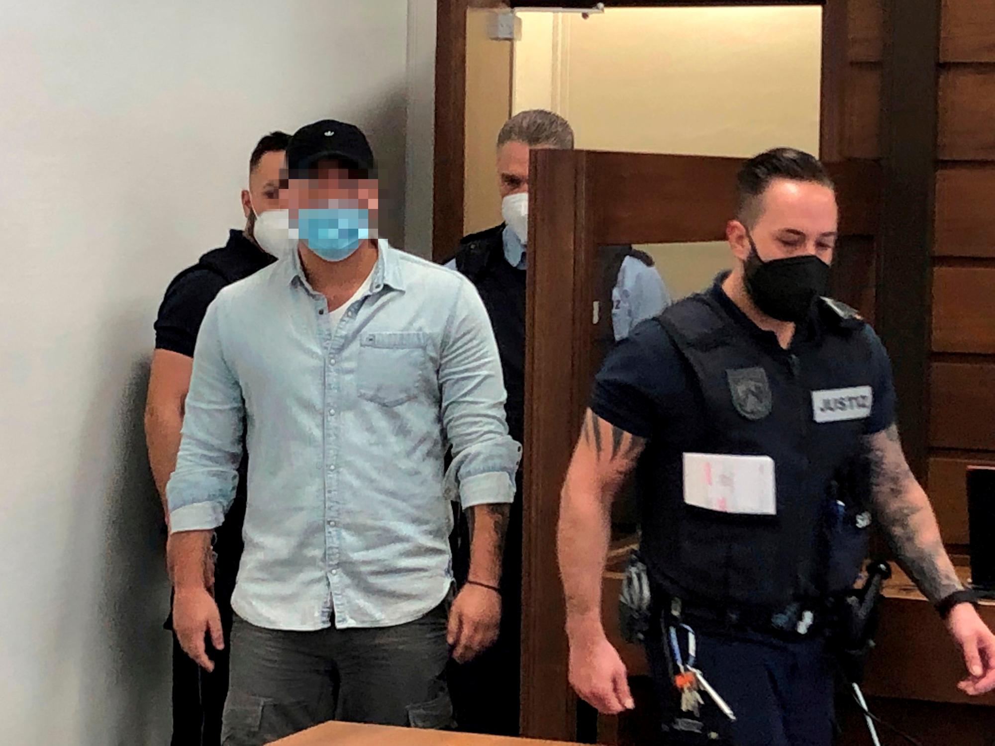Der Nebenkläger wird von Justizbeschäftigten in den Gerichtssaal begleitet.