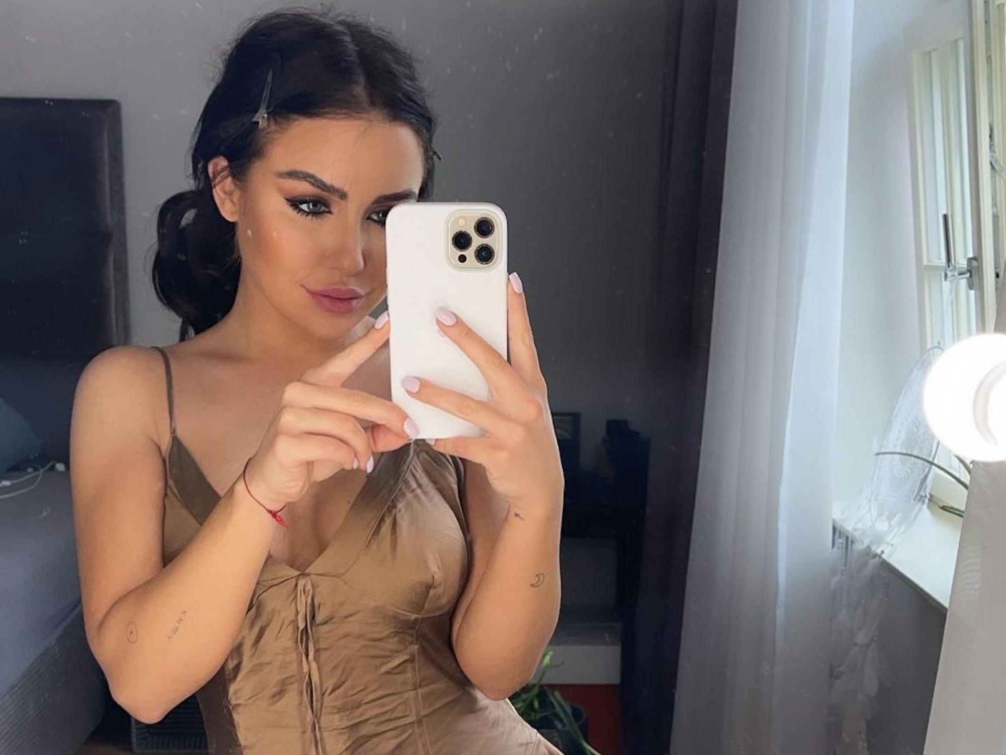Kim Gloss posiert für ein Instagram-Selfie vor einem Spiegel.