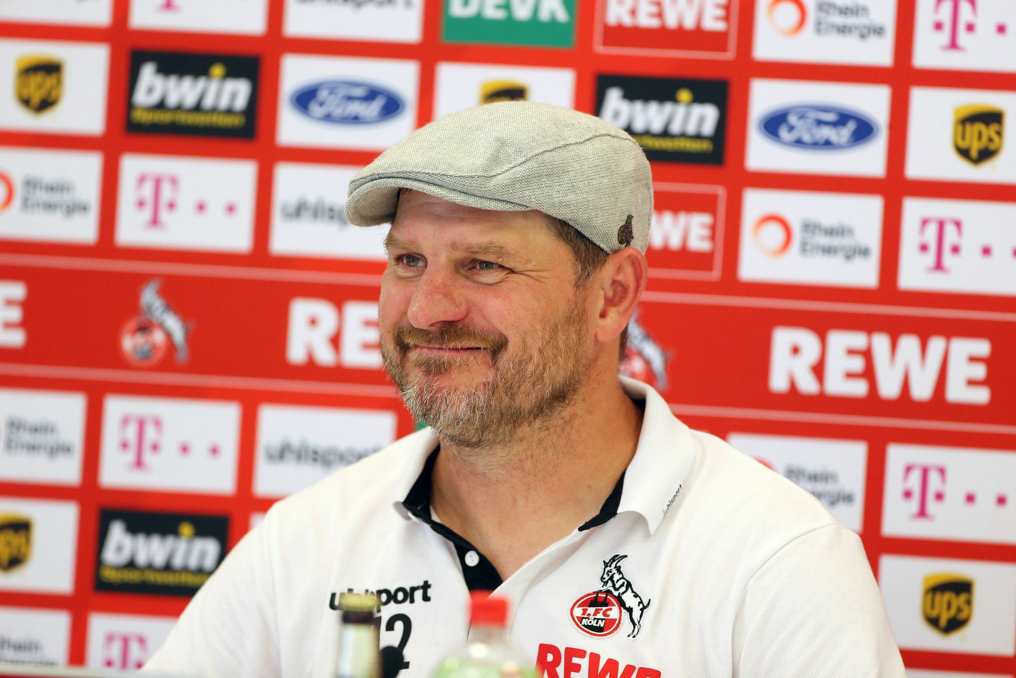 Steffen Baumgart lächelt auf der PK vor dem Spiel gegen Freiburg.