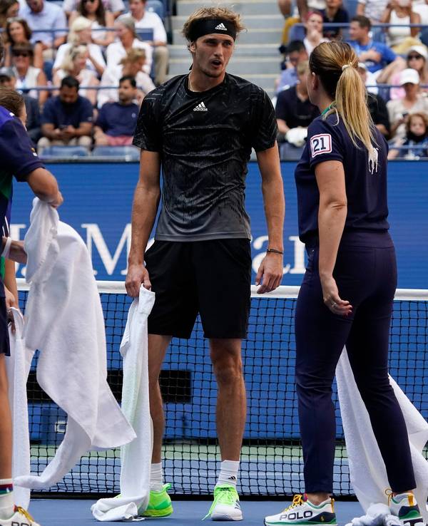 Alexander Zverev, of Germany, talks with court attendants as they dry liquid off the court during the quarterfinals of the US Open tennis championships against Lloyd Harris, of South Africa, Wednesday, Sept. 8, 2021, in New York. (AP Photo/Elise Amendola)