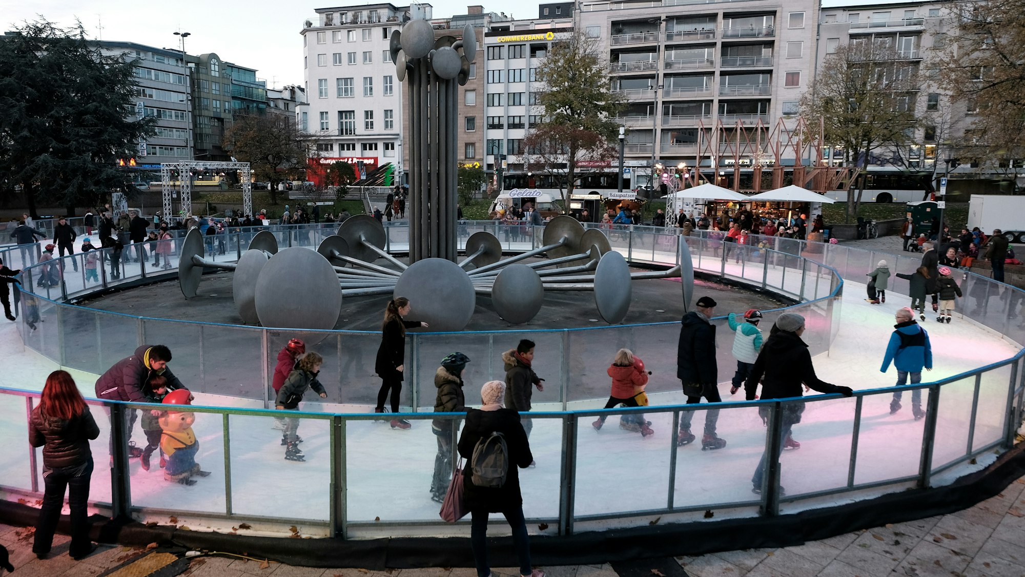 Kinder und Erwachsene laufen auf der Eisbahn am Ebertplatz.