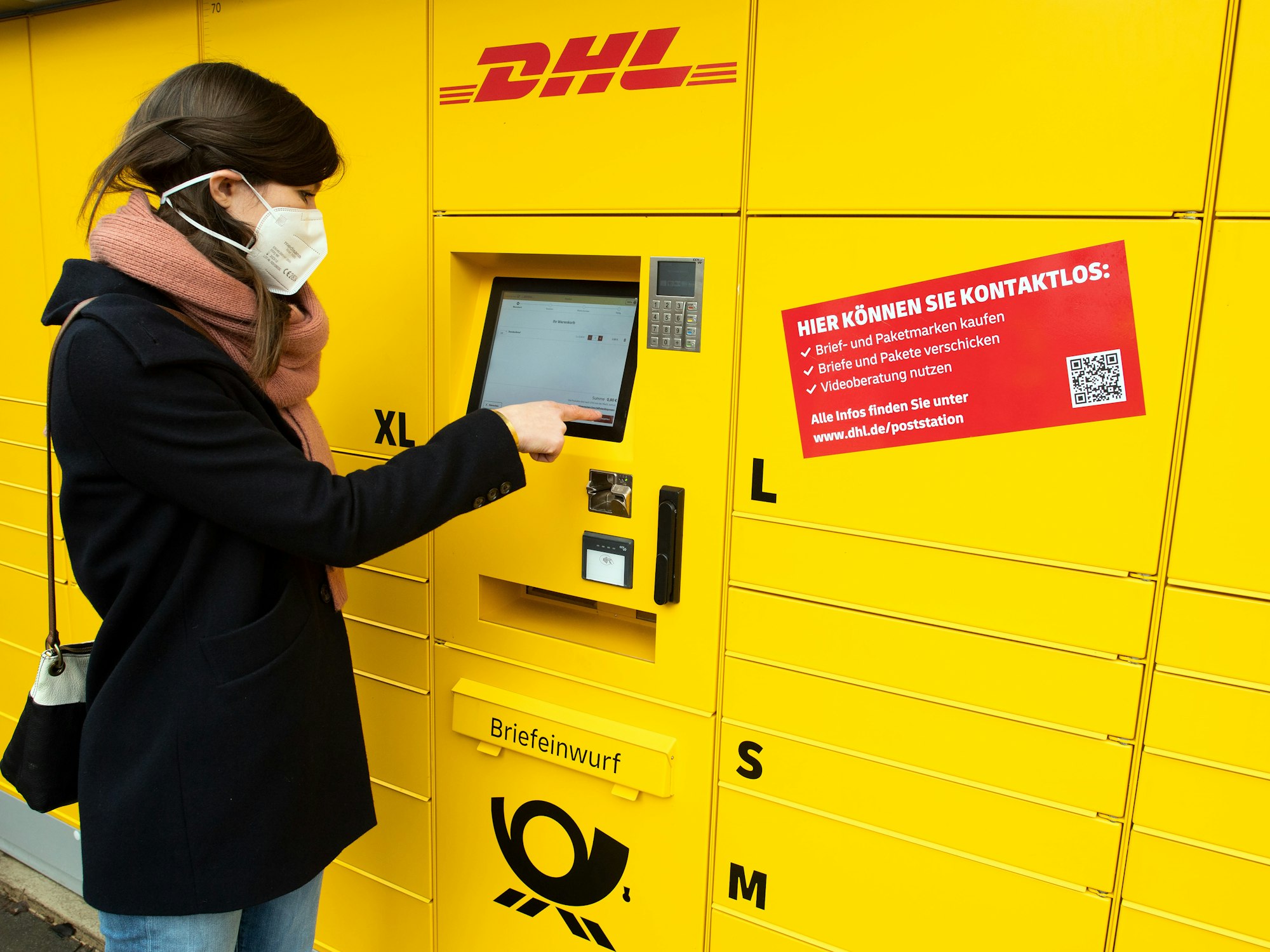 Eine Frau bedient eine neue Poststation.