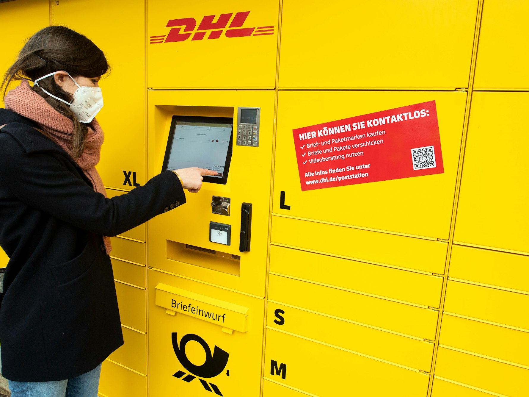 Eine Post-Mitarbeiterin bedient eine neue Poststation.