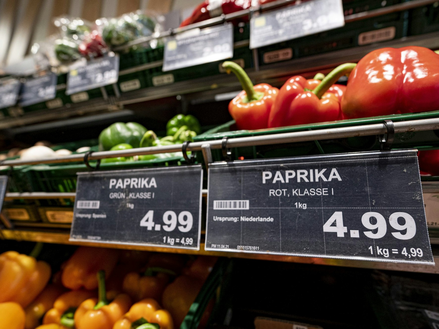 Ein Preisschild von Paprikas hängen an der Obsttheke in einem Supermarkt.