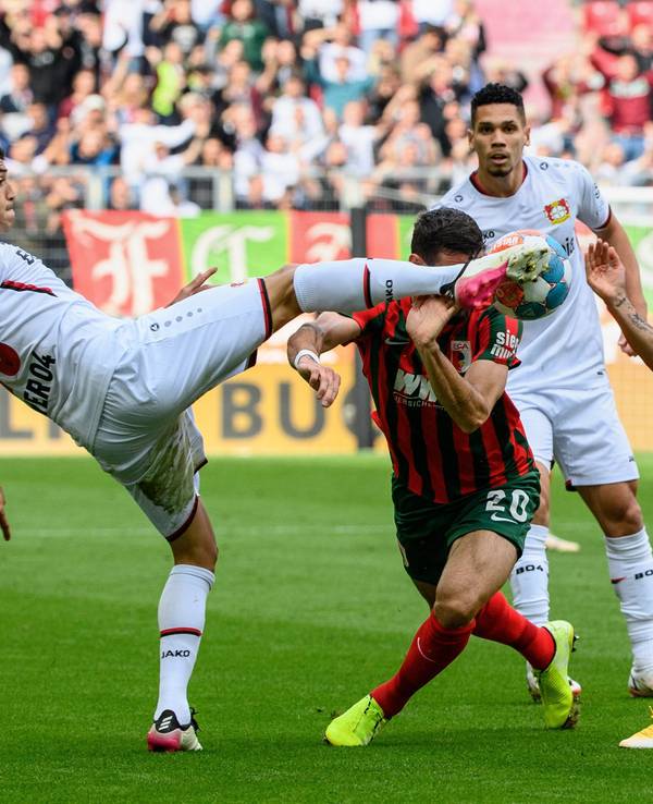 Dreikampf in Augsburg: Exequiel Palacios und Charles Aranguiz stoppen Daniel Caligiuri.