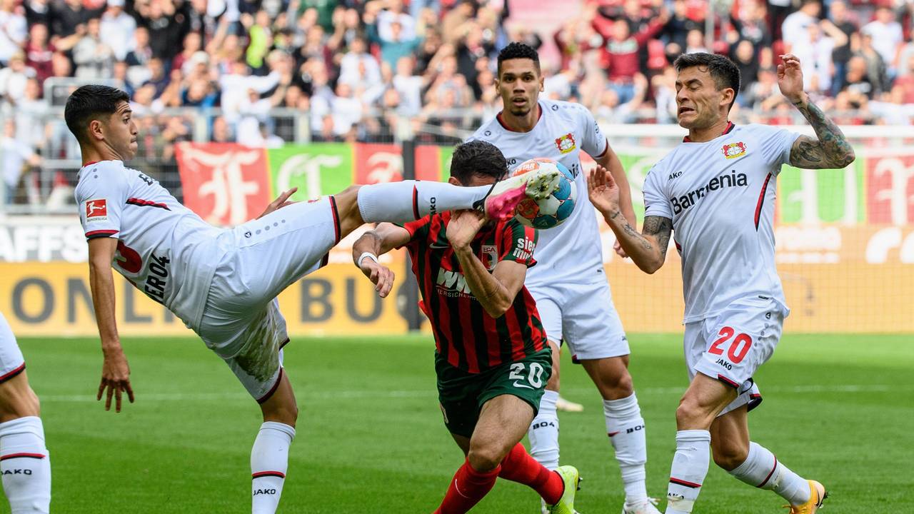 Dreikampf in Augsburg: Exequiel Palacios und Charles Aranguiz stoppen Daniel Caligiuri.