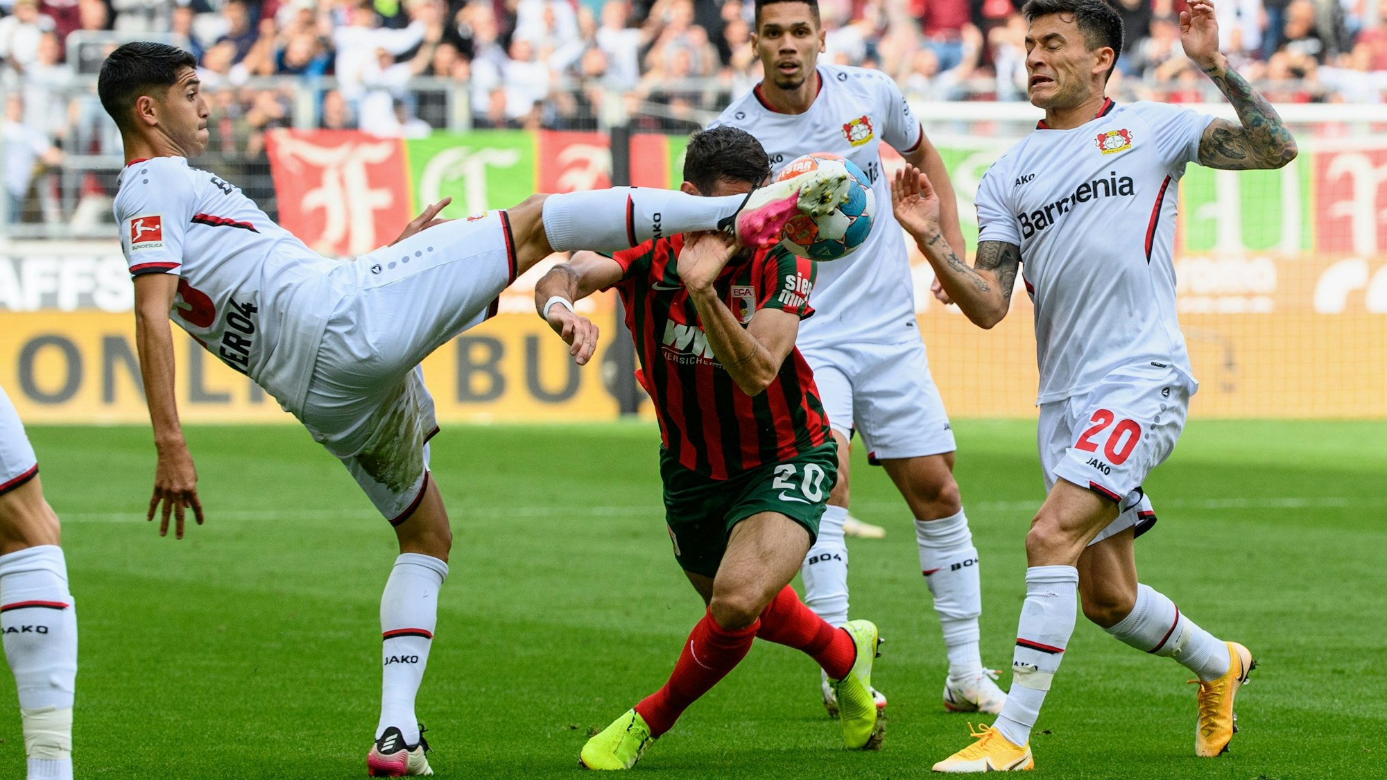 Dreikampf in Augsburg: Exequiel Palacios und Charles Aranguiz stoppen Daniel Caligiuri.