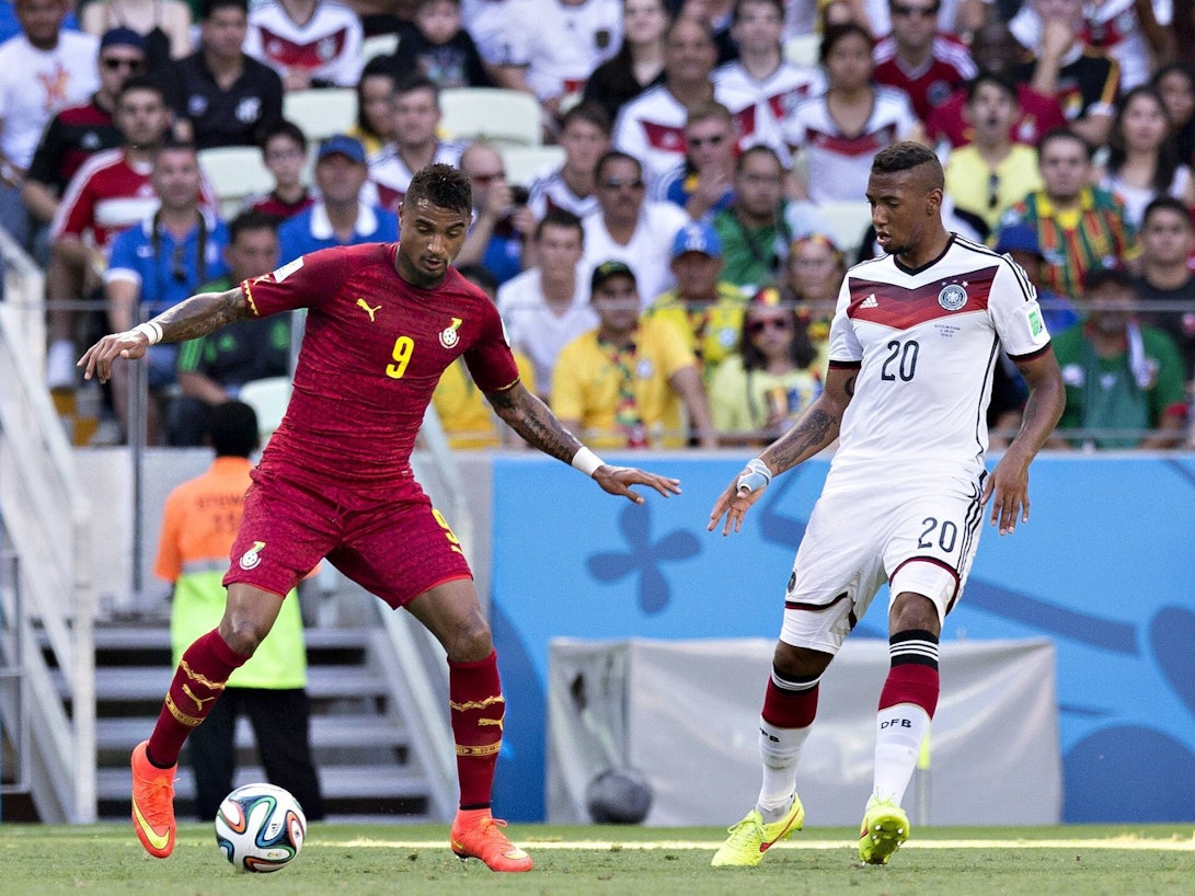 Kevin-Prince Boateng im Trikot von Ghana führt den Ball am Fuß, Jerome Boateng im deutschen Trikot versucht, seinen Halbbruder zu verteidigen.