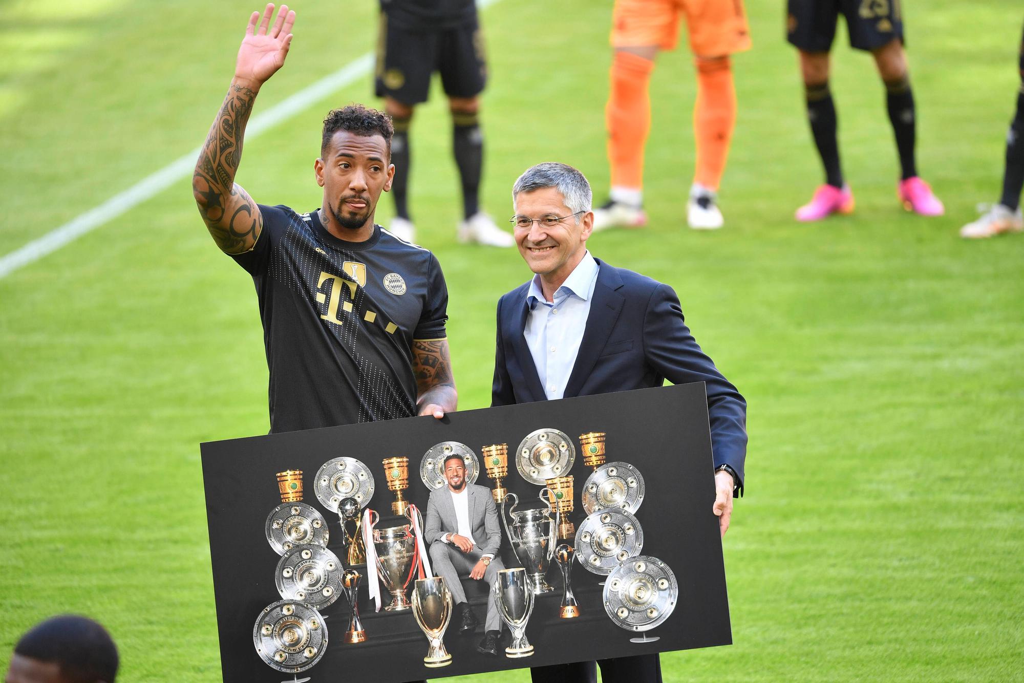 Bayerns Jerome Boateng winkt zum Abschied den Fans. An seiner Seite steht Herbert Hainer, sie halten ein Bild, das Boateng und die von ihm gewonnen Pokale und Titel abbildet.
