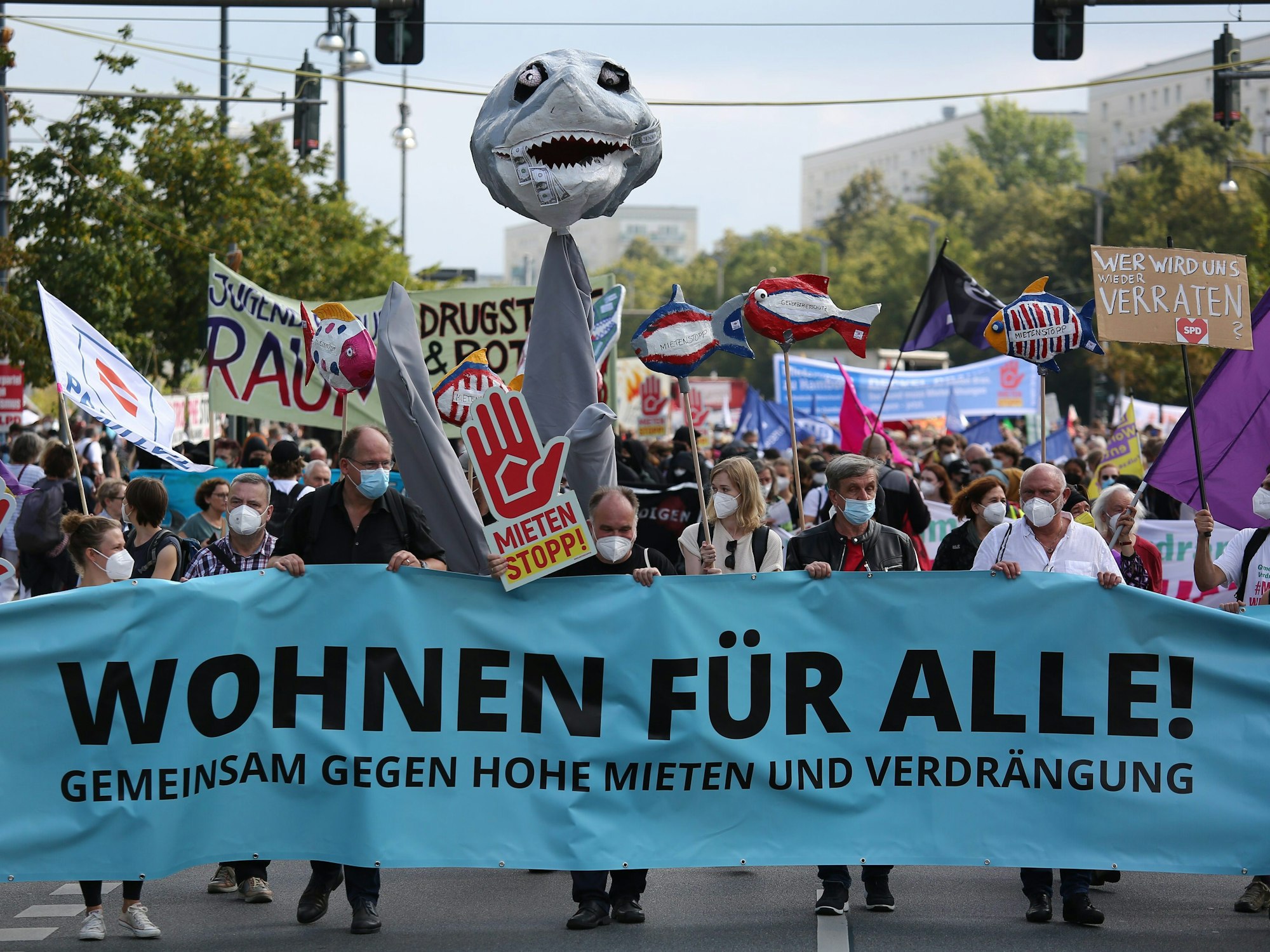 Teilnehmer einer Demo halten ein Plakat.