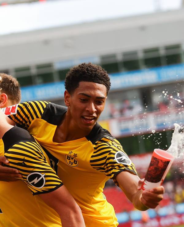 Jude Bellingham von Borussia Dortmund fängt beim Torjubel einen Bierbecher