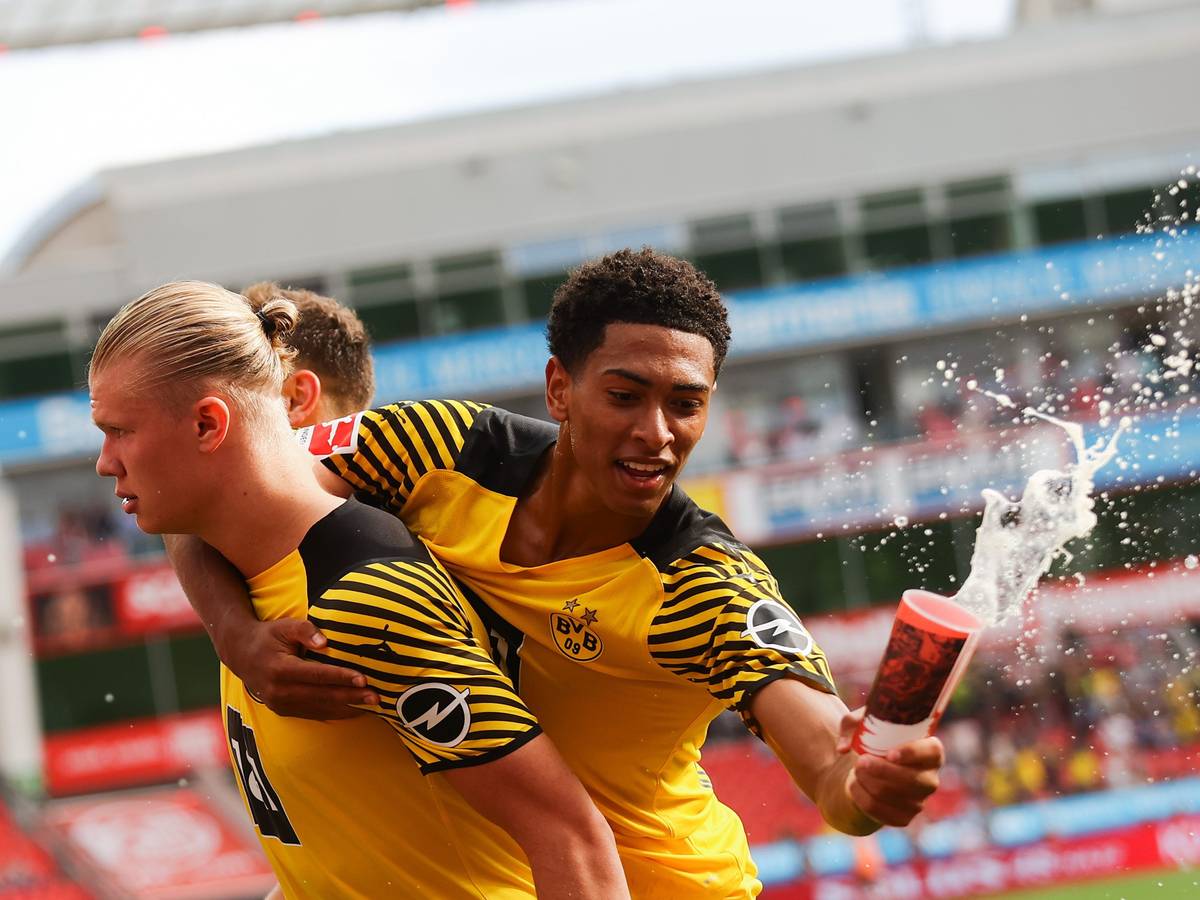 Jude Bellingham von Borussia Dortmund fängt beim Torjubel einen Bierbecher