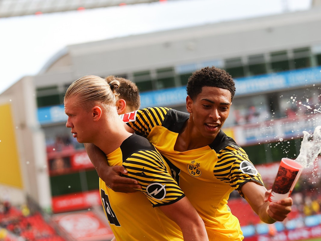 Jude Bellingham von Borussia Dortmund fängt beim Torjubel einen Bierbecher