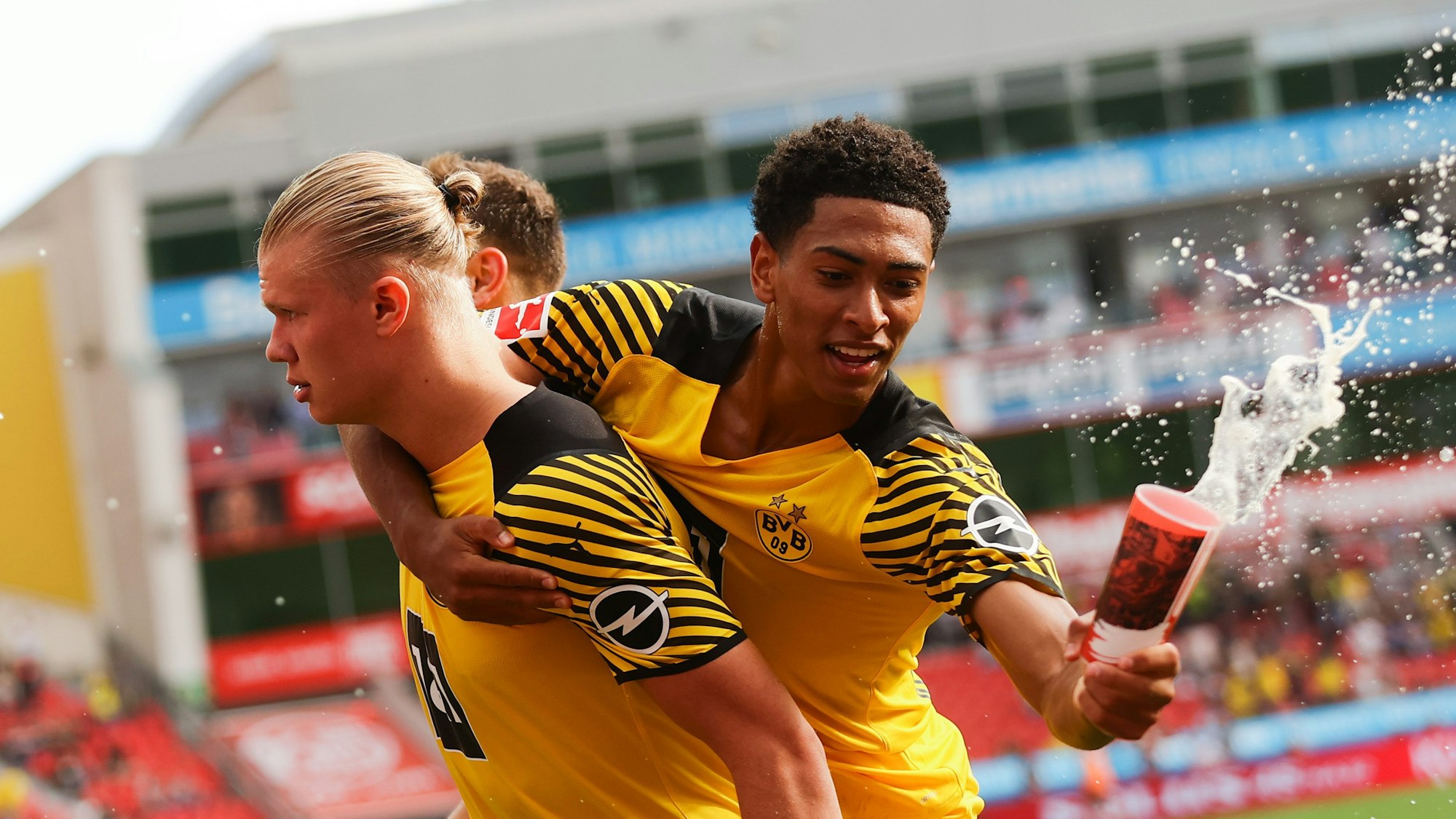 Jude Bellingham von Borussia Dortmund fängt beim Torjubel einen Bierbecher