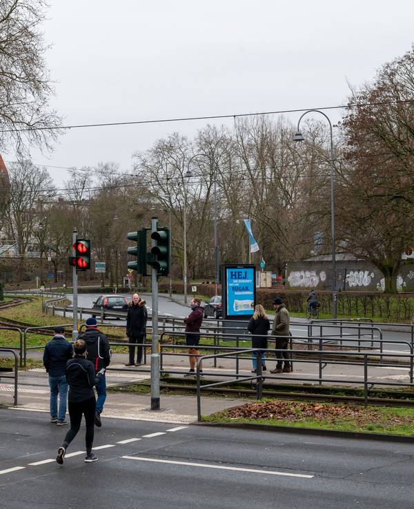 Fußgänger passieren einen Bahnübergang an der Aachener Straße