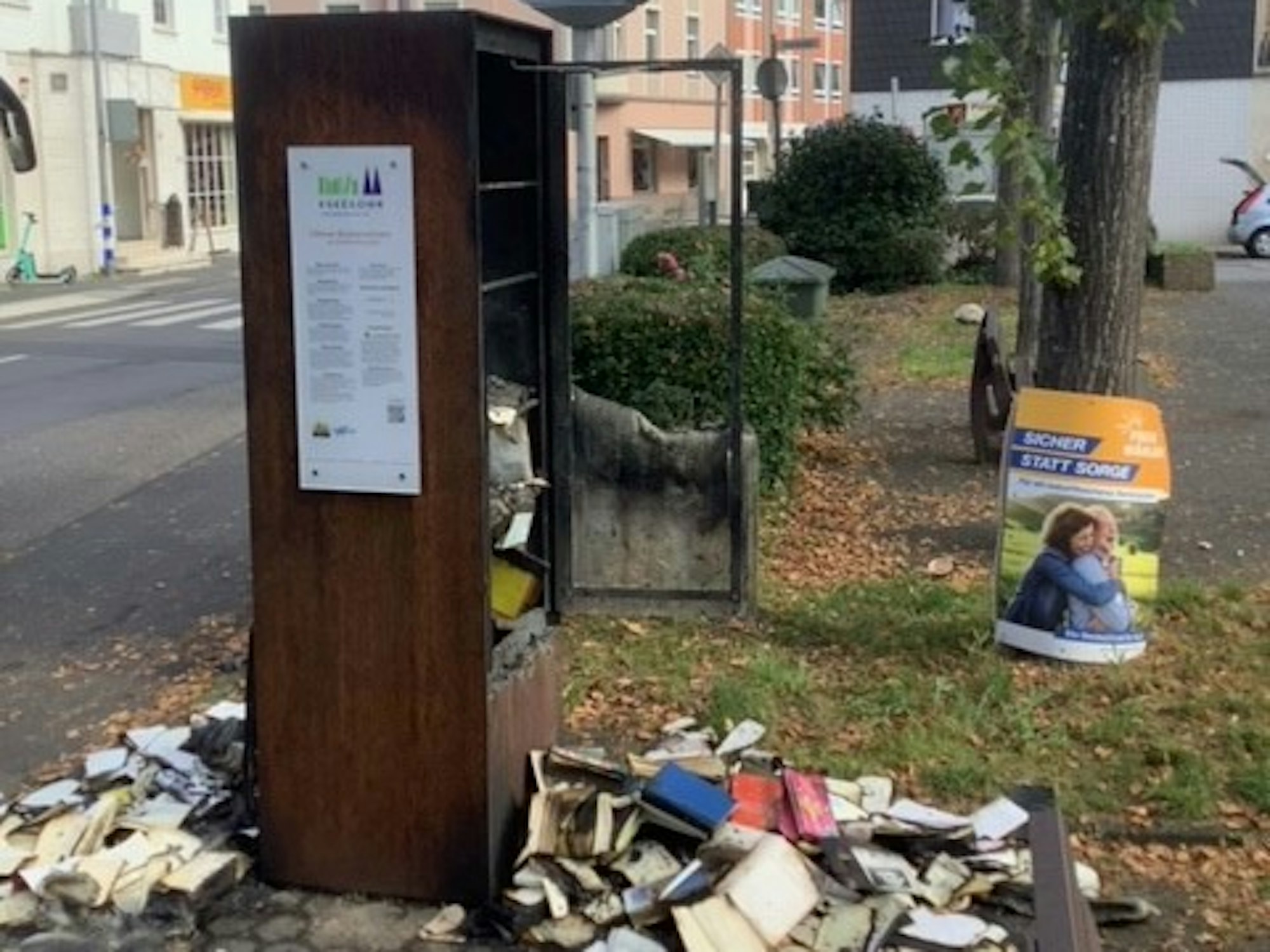 Köln: Der von einem Feuer zerstörte Bücherschrank am Sürther Marktplatz.