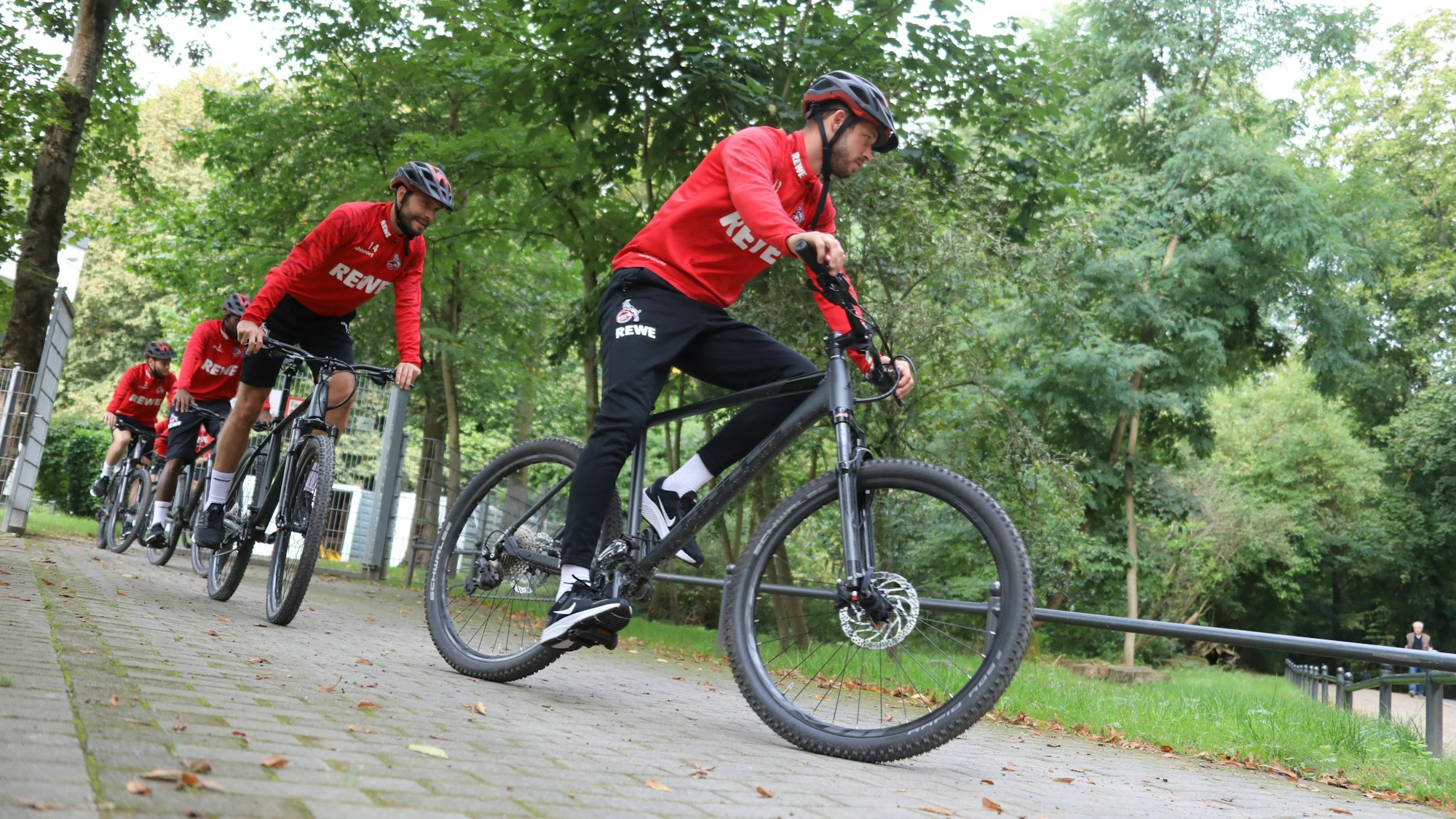 Die Spieler des 1. FC Köln fahren Fahrrad.