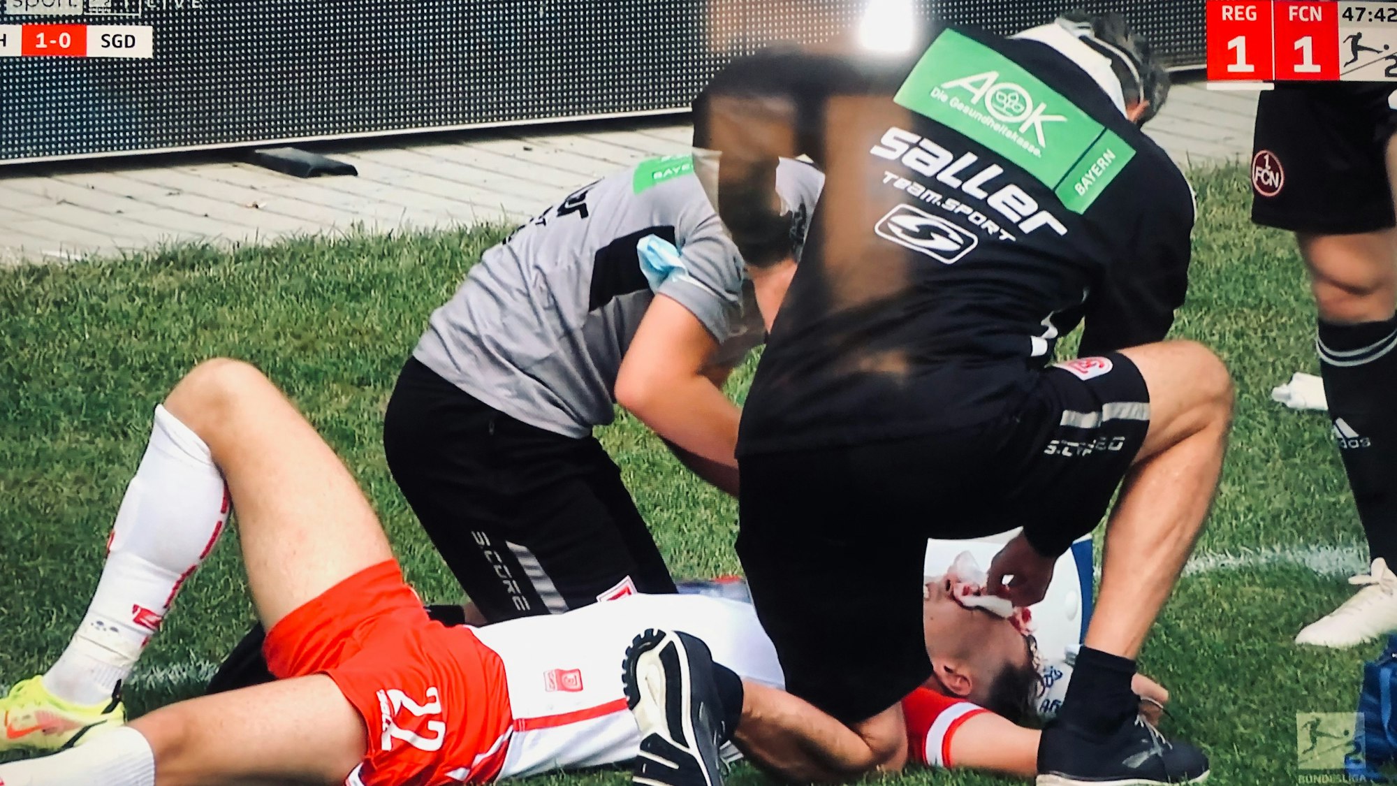 Jahn Regensburgs Carlo Boukhalfa liegt mit einer Kopfverletzung auf dem Rasen