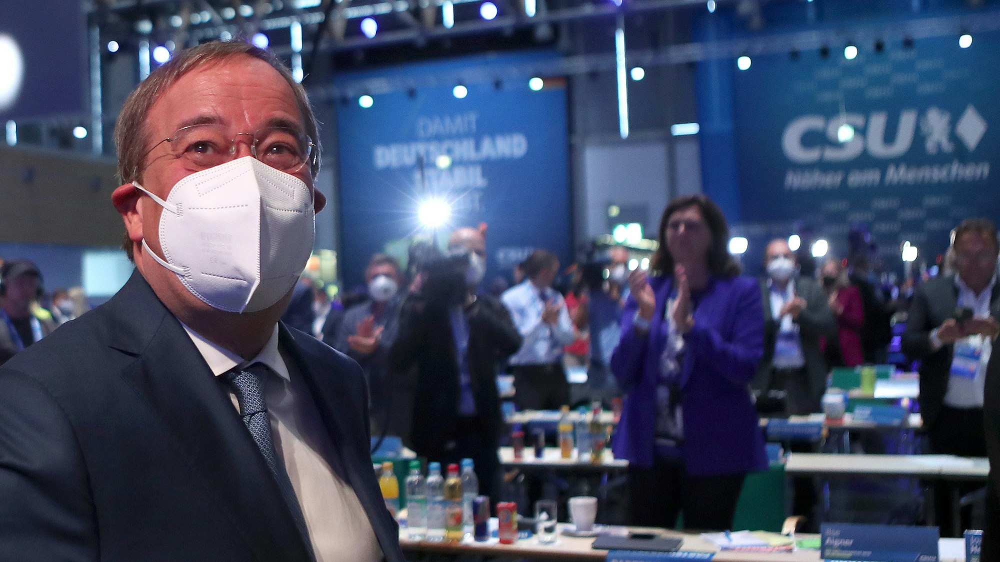 Armin Laschet sitzt mit Mund-Nasen-Schutz beim CSU-Parteitag am Samstag (11. September) in Nürnberg, hinter ihm klatschen die Delegierten.
