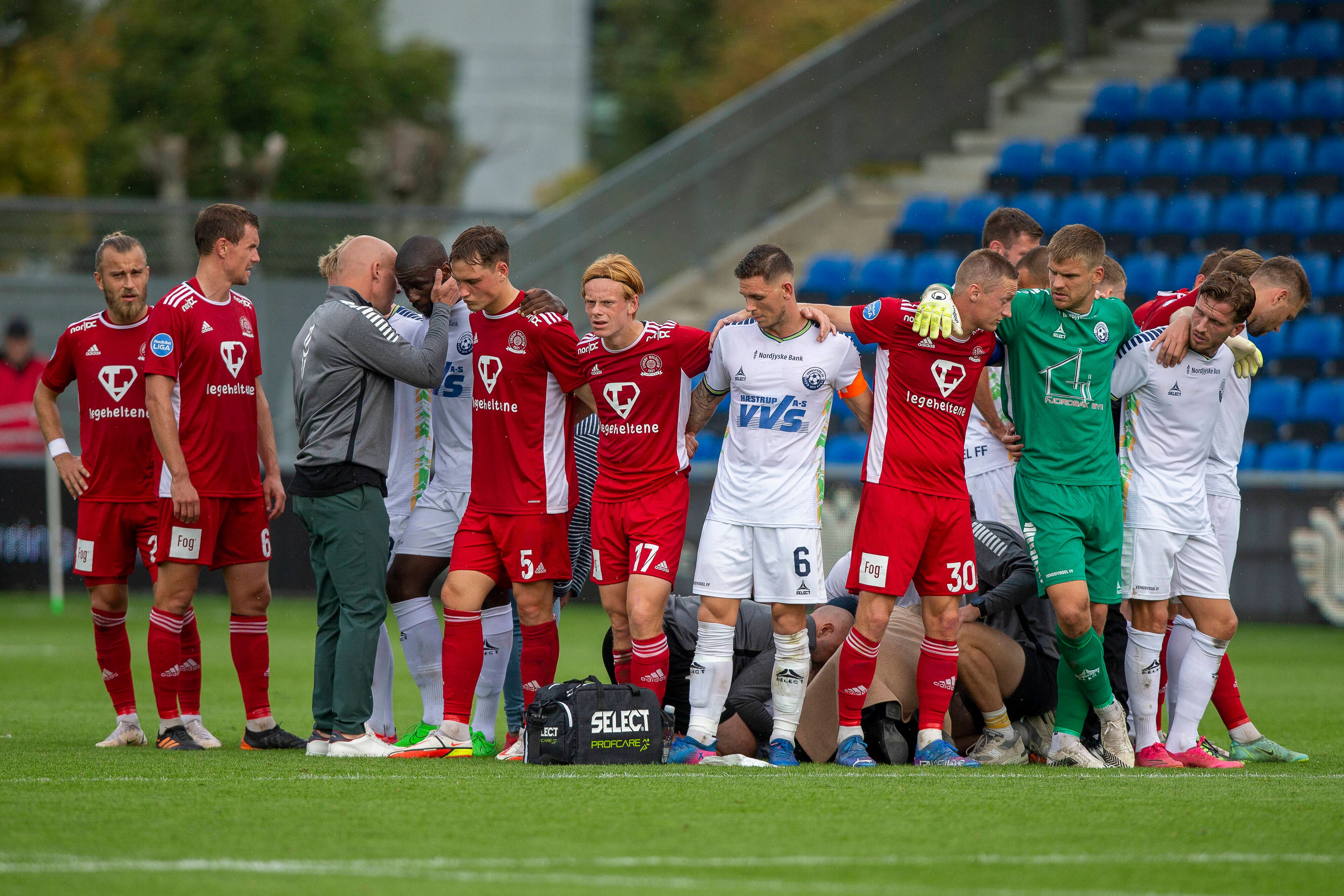 Die Mitspieler von Wessam Abou Ali bilden einen Kreis um den zusammengebrochenen Spieler