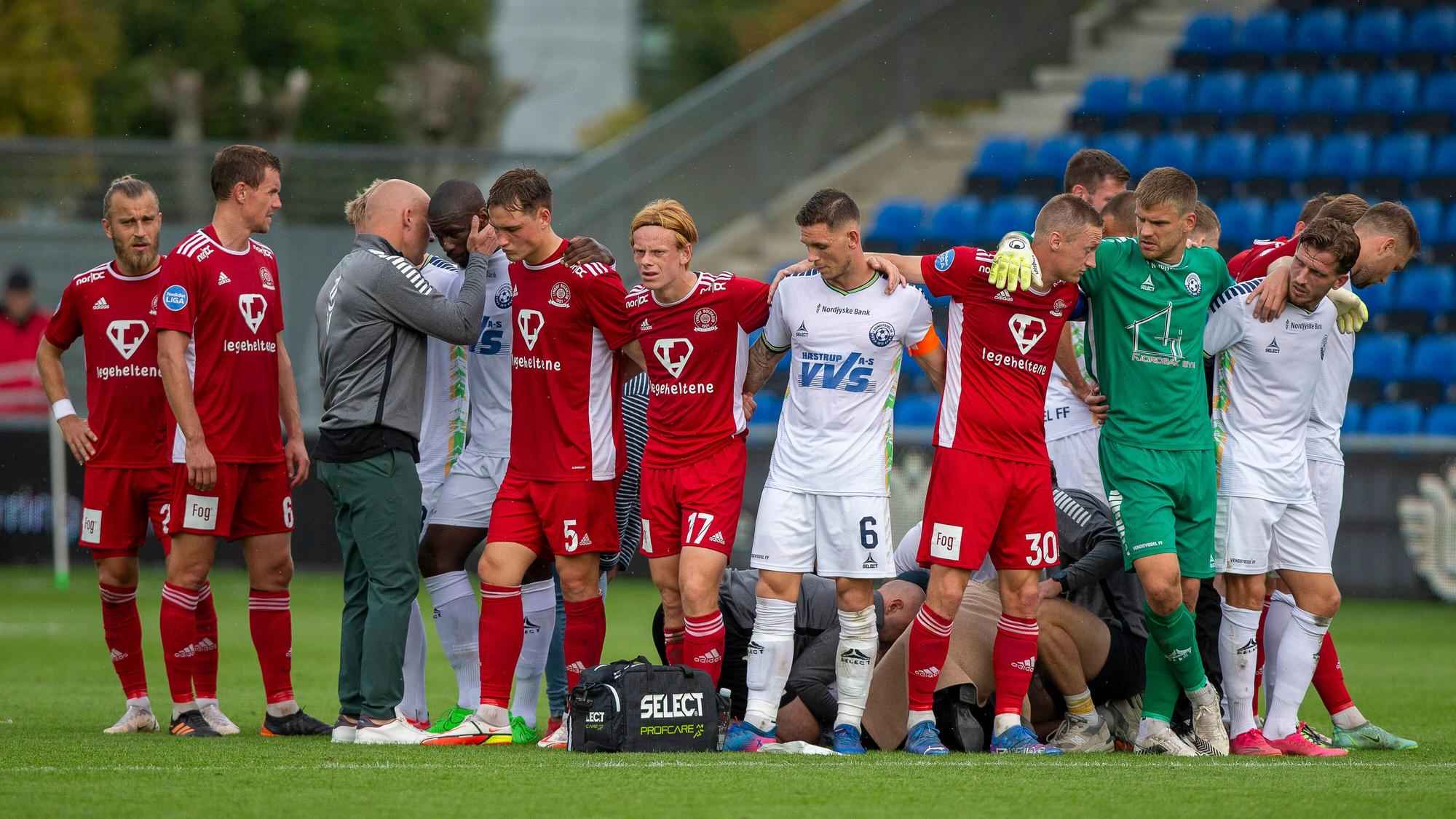Die Mitspieler von Wessam Abou Ali bilden einen Kreis um den zusammengebrochenen Spieler