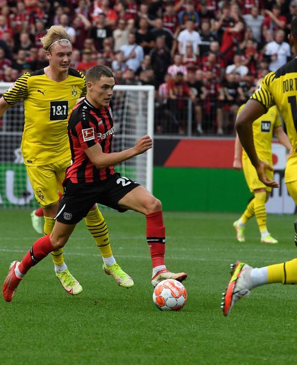 Dortmunds Julian Brandt verfolgt Leverkusens Florian Wirtz.