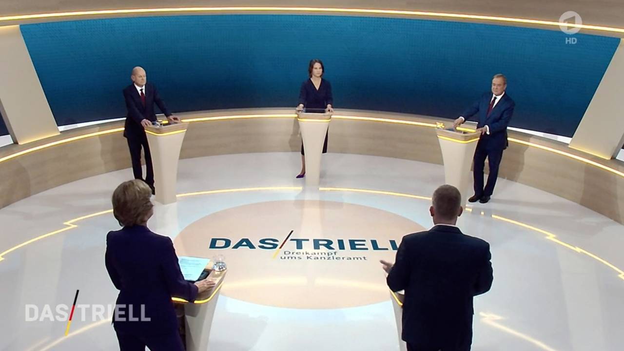 Kanzlerkandidat Olaf Scholz (SPD, hinten, l-r), Kanzlerkandidatin Annalena Baerbock (Bündnis 90/Die Grünen) und Kanzlerkandidat Armin Laschet (CDU) reden miteinander im Fernsehstudio.